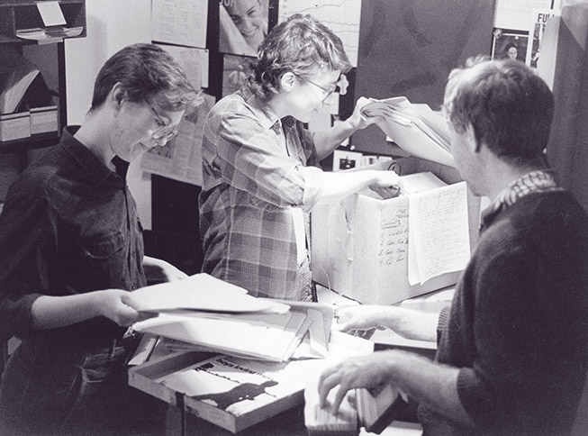 picture of members of the original PTP collective sorting through file boxes